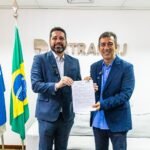 Fabiano dos Santos (Correios) e Vinicius Farah (Detran RJ) com o documento assinado