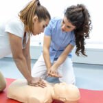 CPR class with instructors talking and demonstrating firt aid, compressions ans reanimation procedure. Cpr dummy